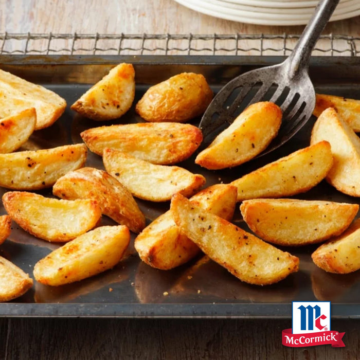 Goldbraune Kartoffelspalten, gewürzt und verzehrfertig auf einem Backblech mit einem Schaumlöffel, unterstreichen die kulinarischen Anwendungen von Mccormick De Global Template All Rounders.