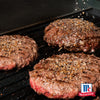 Drei gewürzte Hamburger-Patties, zubereitet mit Mccormick De Global Template All Rounders, grillen auf einem schwarzen Rost, mit dem McCormick-Logo sichtbar.
