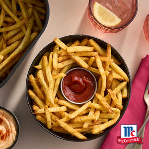 Eine SchA?ssel Pommes Frites mit Ketchup in der Mitte, die das McCormick-Markenlogo zeigt.