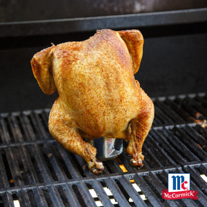 Ein ganzes Hähnchen das mit Srpet Chick Seas X06-Ge gewürzt wurde wird aufrecht auf einer Bierdose über einem heißen Grillrost mit dem McCormick Logo gegrillt.