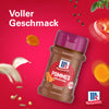 Eine Flasche McCormick Srpet Chip Seas X06-Ge wird vor einem leuchtend roten Hintergrund präsentiert, umgeben von schwebenden Zutaten wie Knoblauch und Kurkuma, um den vollen Geschmack zu betonen.