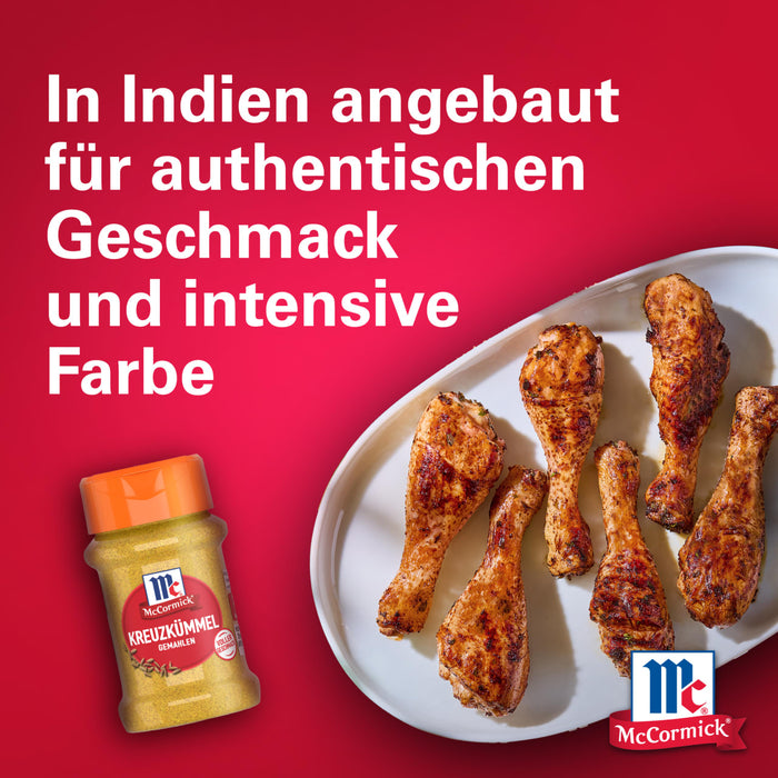 Eine Flasche Srpet Cinnamon Gd X06-Ge Kreuzkümmel gemahlen von McCormick steht neben einem Teller mit gewürzten Hähnchenschenkeln und deutschem Text über die authentische Herkunft aus Indien.