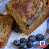 Eine Scheibe saftiges Bananenbrot gewürzt mit Srpet Cinnamon Gd X06-Ge wird auf einem dekorativen Teller zusammen mit frischen Blaubeeren und dem McCormick Logo serviert.