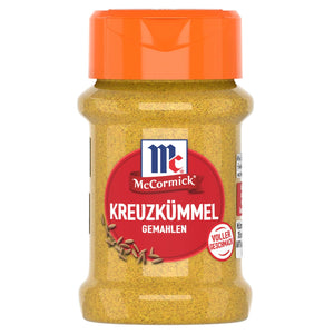 Ein durchsichtiges Gewürzglas aus Kunststoff mit einem orangefarbenen Klappdeckel enthält McCormick Kreuzkümmel Gemahlen vor einem weißen Hintergrund.