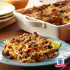 Eine herzhafte Portion mexikanische Lasagne mit schwarzen Bohnen, Mais und Hackfleisch, gewürzt mit Srpet Cumin Gd X06-Ge, auf einem blauen Teller mit dem McCormick-Logo in der Ecke.