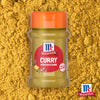 Eine Flasche McCormick Srpet Curry X06-Ge Gewürzmischung steht zentriert vor einem Hintergrund aus losem gelbem Currypulver.