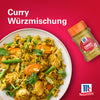 Eine appetitliche Schüssel mit Hähnchen-Gemüse-Reis wird neben einer Flasche Srpet Curry X06-Ge von McCormick präsentiert.