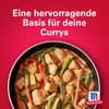 Eine Pfanne gefüllt mit einem cremigen Hähnchen- und Gemüsegericht mit Srpet Curry X06-Ge von McCormick vor einem leuchtend roten Hintergrund.