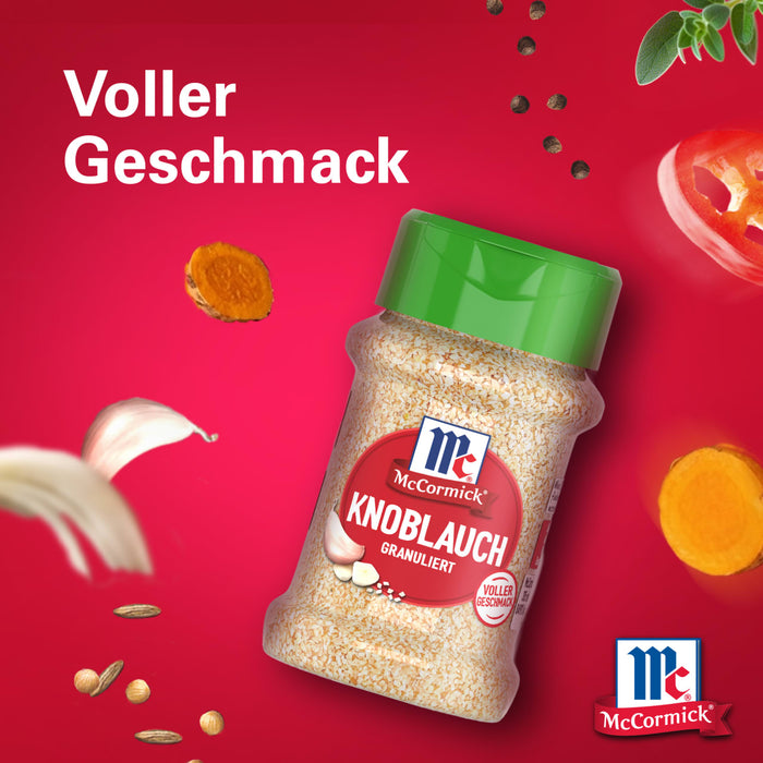 Eine Flasche Srpet Garlic Granul X06-Ge von McCormick ist von schwebenden Zutaten wie Knoblauchzehen und Pfefferkörnern vor einem leuchtend roten Hintergrund mit dem Text Voller Geschmack umgeben.