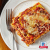 Ein herzhaftes Stück geschichtete Lasagne mit geschmolzenem Käse und einer Prise Srpet Oregano X06-Ge neben dem McCormick Logo.
