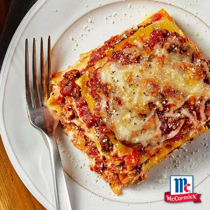 Ein herzhaftes Stück geschichtete Lasagne mit geschmolzenem Käse und einer Prise Srpet Oregano X06-Ge neben dem McCormick Logo.