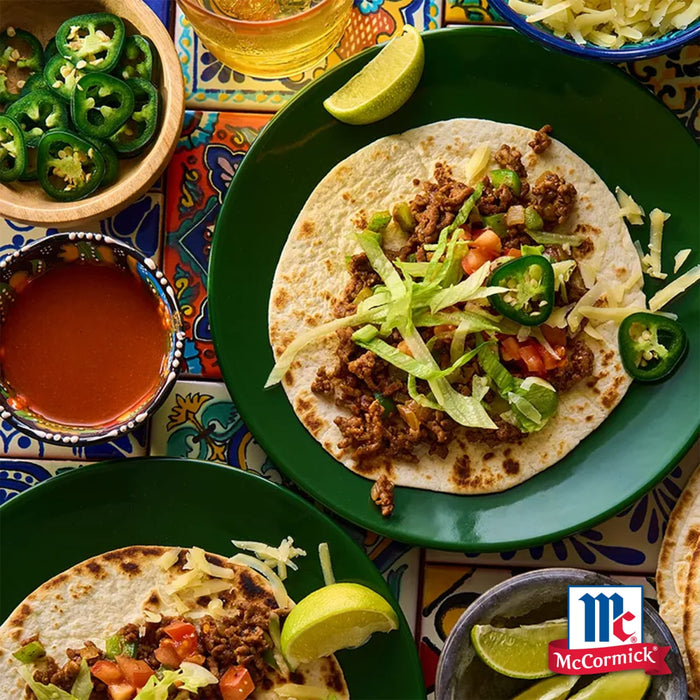 Eine lebendige Auswahl an Rindfleisch-Tacos mit Salat und Tomaten wird durch die herzhaften Noten von Srpet Oregano X06-Ge zusammen mit frischen Limettenspalten und geschnittenen Jalapeños verfeinert.