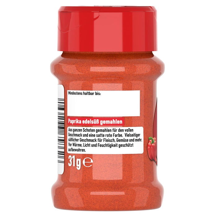 Ein durchsichtiges Gewürzglas mit rotem Deckel ist mit edelsüßem Paprikapulver gefüllt und zeigt das rückseitige Etikett mit dem deutschen Text für Paprika edelsüß gemahlen.