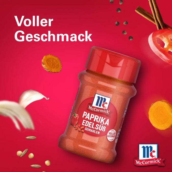 Eine Flasche Srpet Paprika Sweet X06-Ge von McCormick ist von schwebenden Zutaten wie Knoblauch und Kurkuma vor einem leuchtend roten Hintergrund mit dem Text Voller Geschmack umgeben.