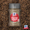 Eine Flasche Srpet Bl Pepper Gd X06-Ge mit McCormick Pfeffer Schwarz Gemahlen steht zentriert vor einem Hintergrund aus grob gemahlenem schwarzem Pfeffer.