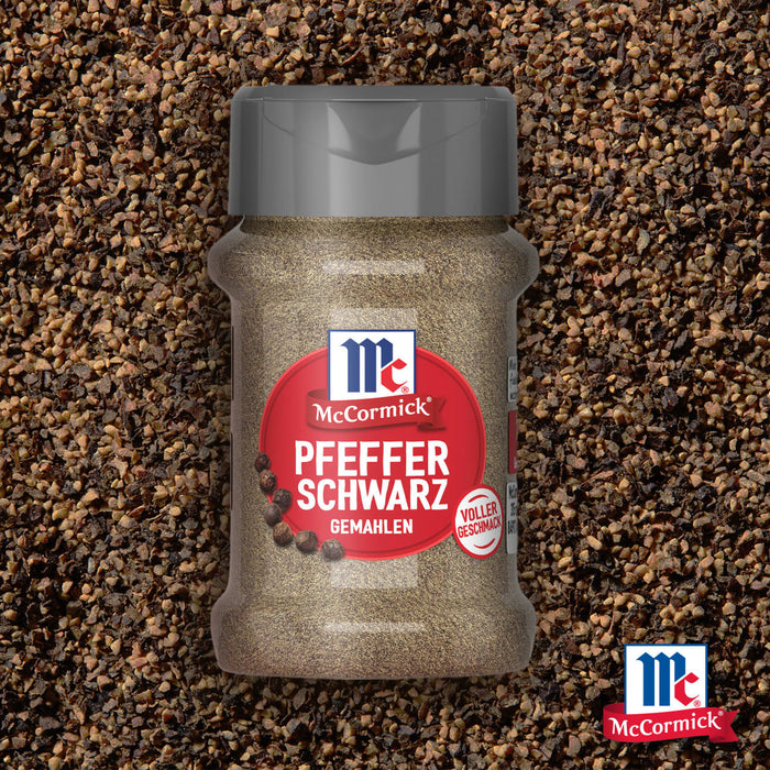 Eine Flasche Srpet Bl Pepper Gd X06-Ge mit McCormick Pfeffer Schwarz Gemahlen steht zentriert vor einem Hintergrund aus grob gemahlenem schwarzem Pfeffer.