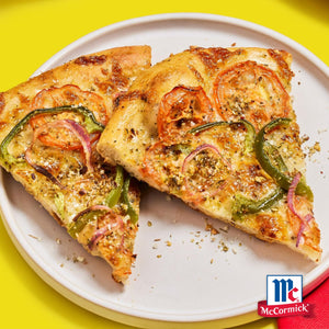 Zwei Stücke Gemüsepizza mit Tomaten, grüner Paprika und roten Zwiebeln sind mit Srpet Pizza Seas X06-Ge gewürzt und werden auf einem weißen Teller mit dem McCormick Logo präsentiert.