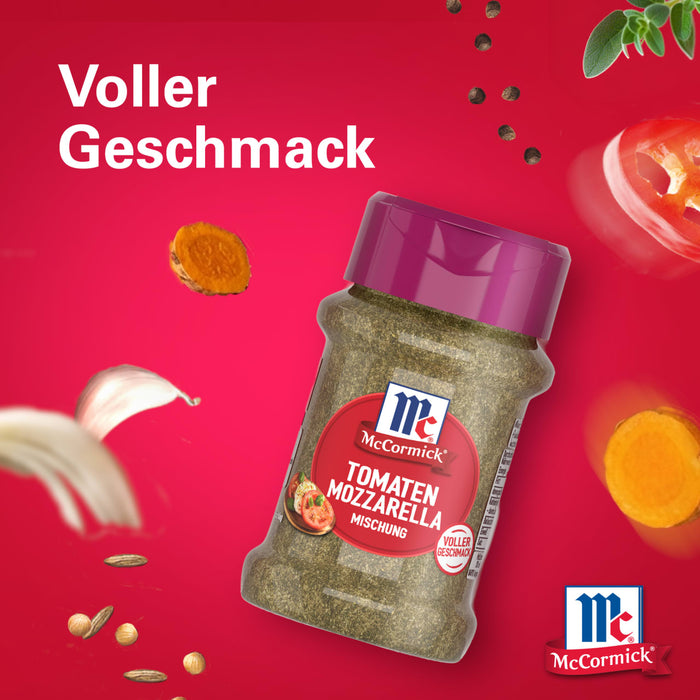 Eine Flasche McCormick Srpet Tomato Mozza X06-Ge Gewürzmischung schwebt vor einem leuchtend roten Hintergrund umgeben von frischen Zutaten wie Knoblauch und Pfefferkörnern um den vollen Geschmack zu betonen.