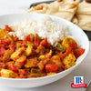 Eine weiße Schüssel gefüllt mit einem lebhaften Hühnchen-Curry gewürzt mit Srpet Turmeric X06-Ge serviert neben weißem Reis und warmem Naan-Brot mit dem McCormick-Logo.